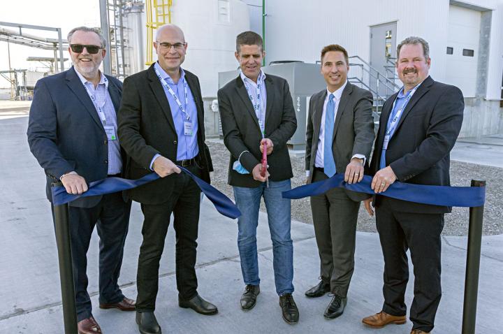 A group of business men cut a ribbon