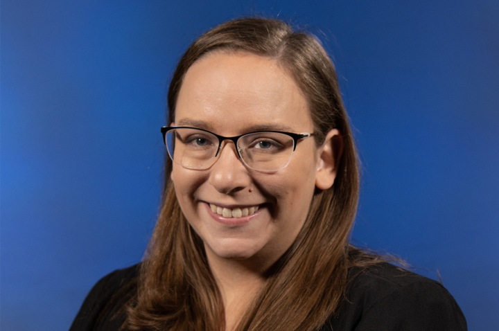 Headshot of Maggie Kost on a blue backgroun