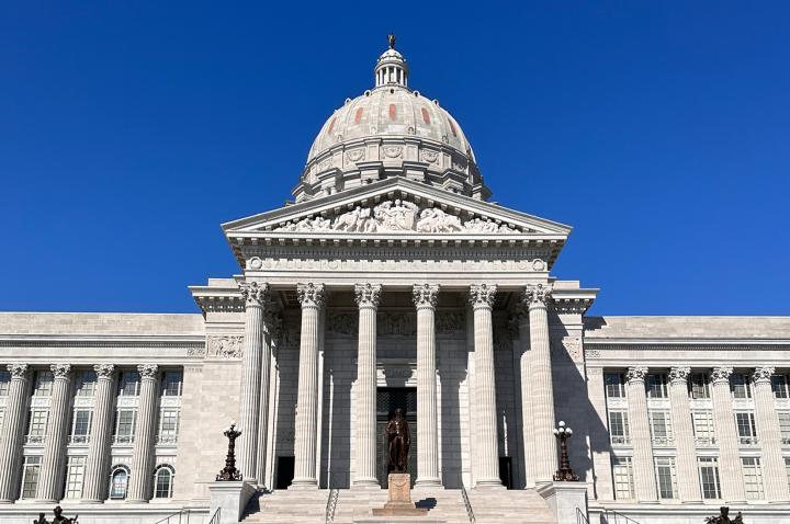 The face of the Missouri Capitol building, set against a deep blue sky