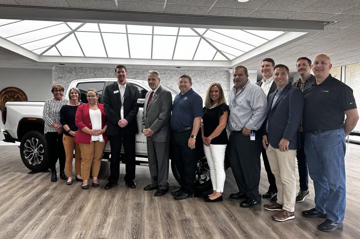 Greater St. Louis, Inc. poses with Wentzville GM representatives in front of a GM truck.