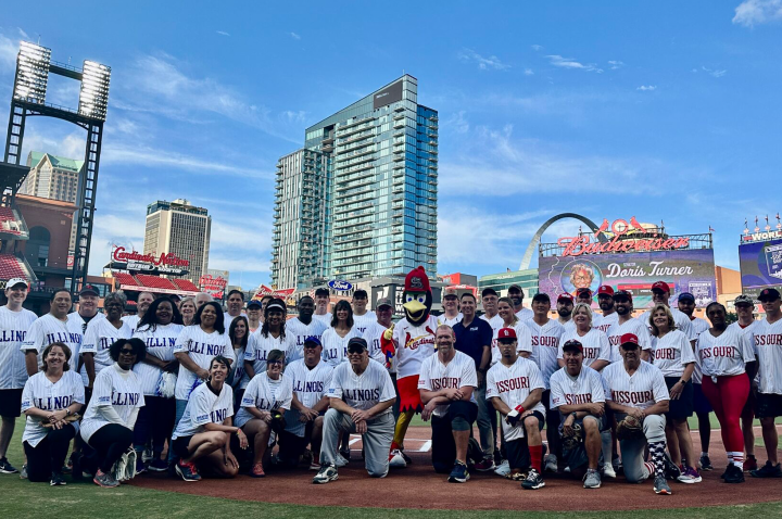 Missouri and Illinois legislatures pose on the field in Busch Stadium during the 2023 Bi-State Softball Showdown