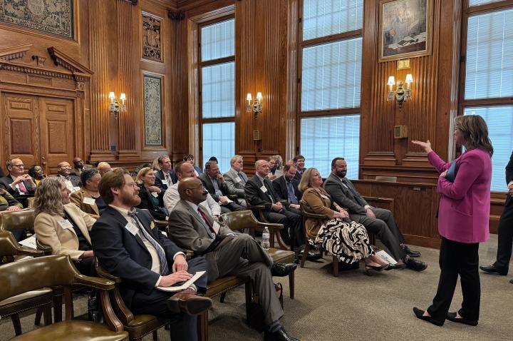 A Missouri legislator talks to a group of seated guests at the Missouri Capitol.