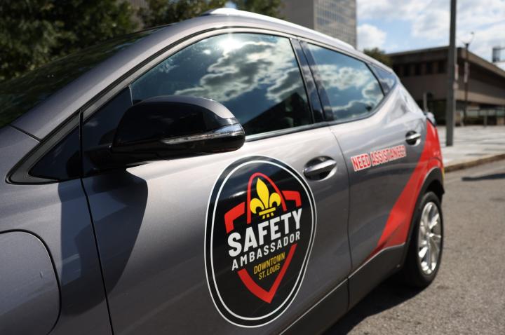 A photo of a gray car wrapped in the Downtown Public Safety Ambassador program logo.