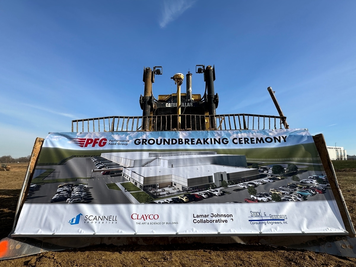 IMG_3480-1200×900-e339a72 Caterpillar bulldozer displaying a Groundbreaking Ceremony banner with a site rendering and company logos