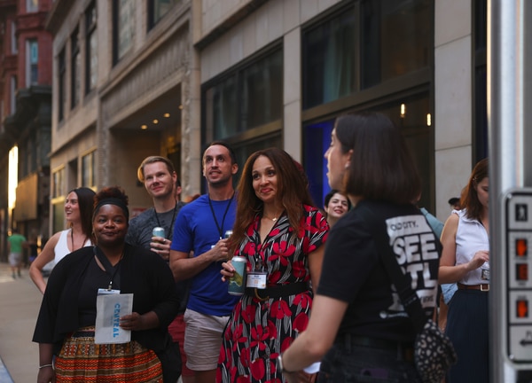 Stainless-steel Gateway Arch towering over a broad green park with a circular fountain and walkways, framing the downtown St. Louis skyline under a bright blue sky.