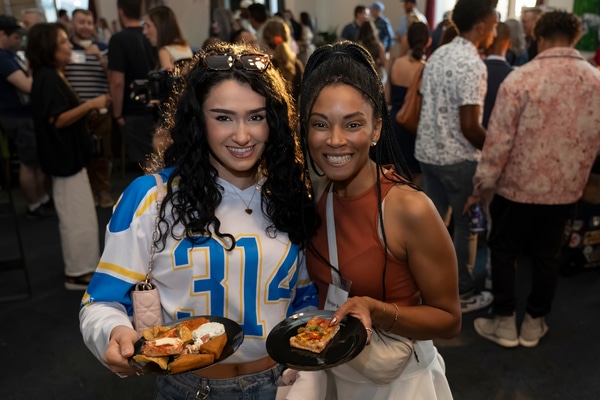 Front façade of a red-brick building housing the National Blues Museum, with a vintage marquee reading Blues Museum, tall green-framed windows, decorative stone trim, and several cars parked along the street.