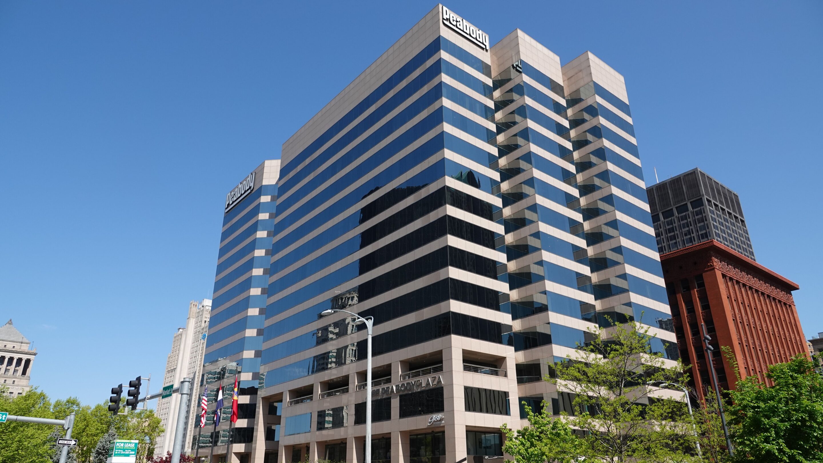 Modern Peabody Plaza office tower with alternating blue reflective glass and white bands under a clear blue sky.