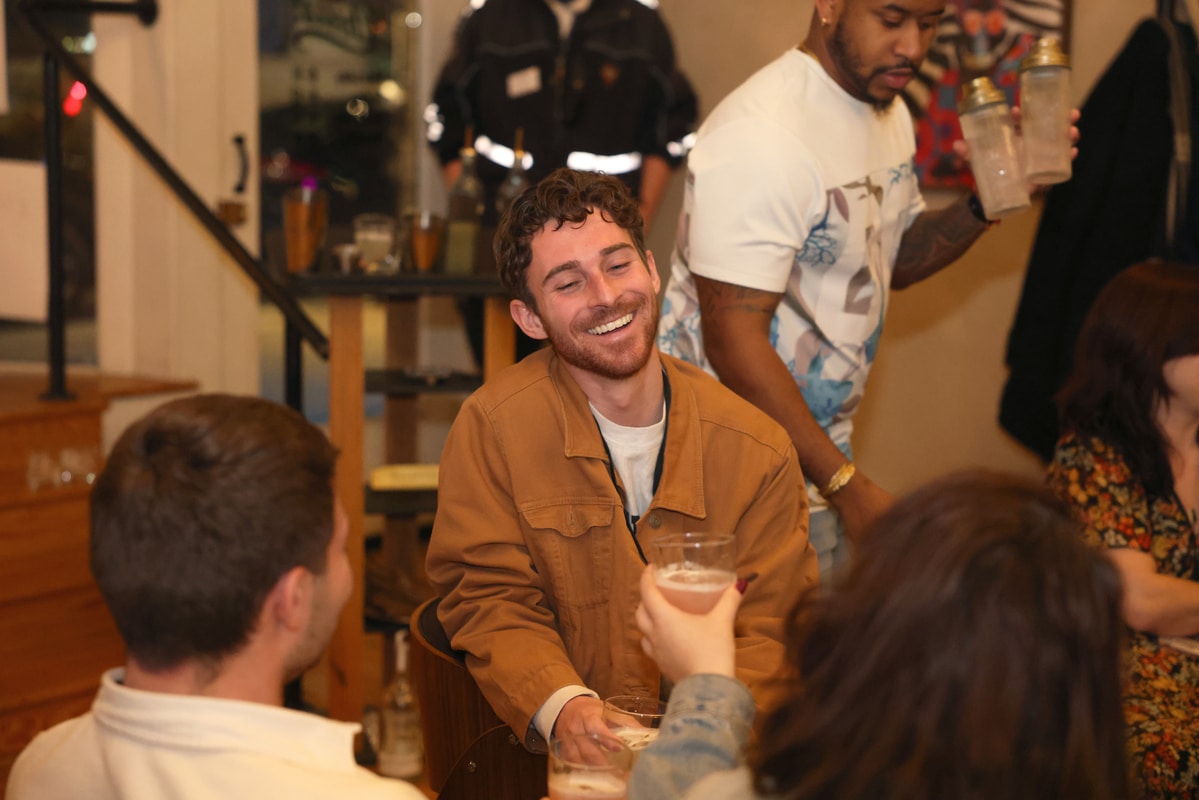 Stainless-steel Gateway Arch towering over a broad green park with a circular fountain and walkways, framing the downtown St. Louis skyline under a bright blue sky.