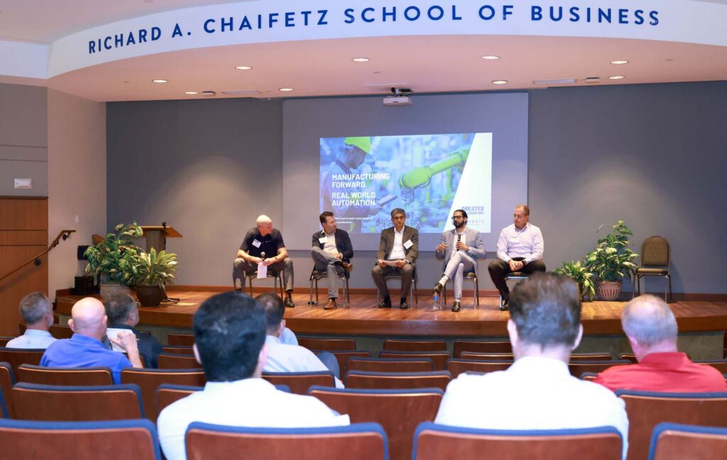 Five panelists on stage before an audience at the Richard A. Chaifetz School of Business manufacturing automation event