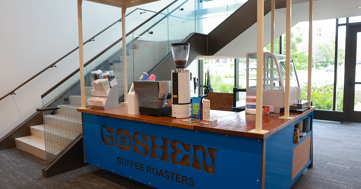 Blue Goshen Coffee Roasters cart with espresso machine and grinder set under a staircase in a lobby